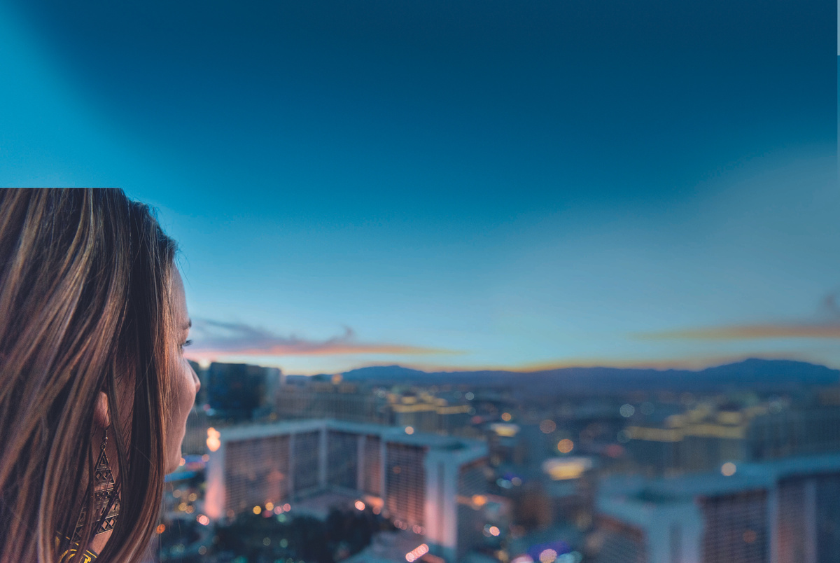 A picture of a woman in profile looking out over a city skyscape at dusk. This is the image that is associated with the ANZ Return to Work Program